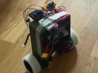 Zingu, a two-wheeled self-balancing robot, upright on a wooden floor